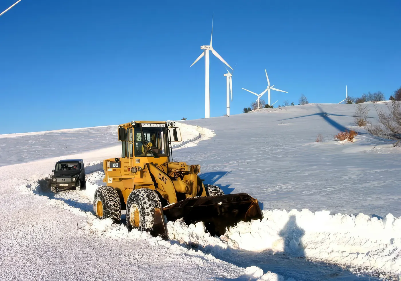 Cargadora abriendo una pista nevada en un parque eólico del norte de Burgos