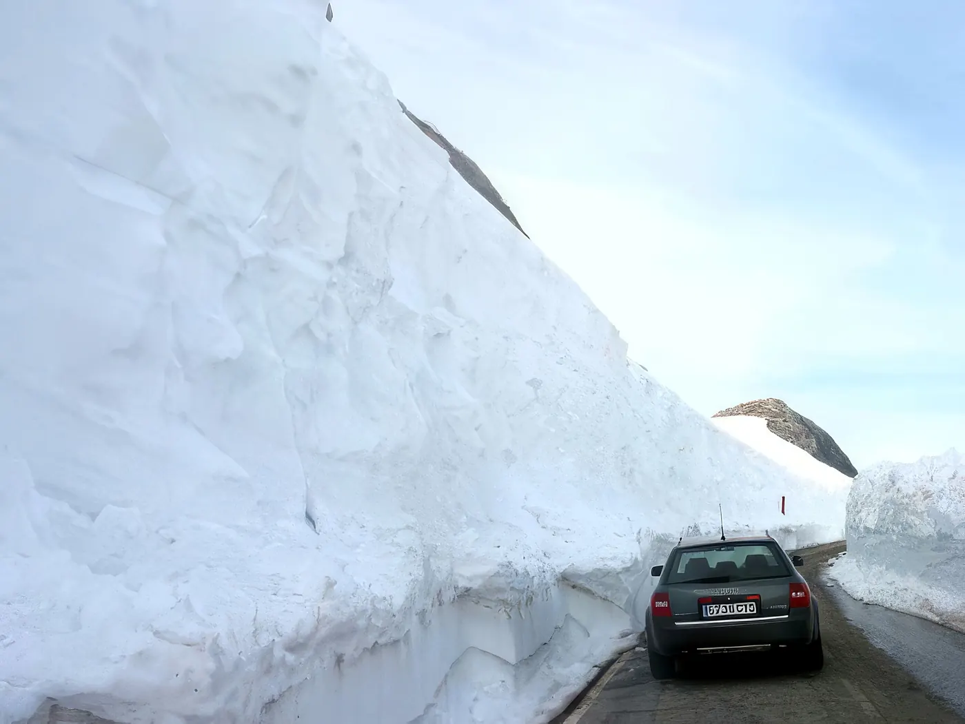 Coche entre paredes de nieve en el acceso al EVA-12