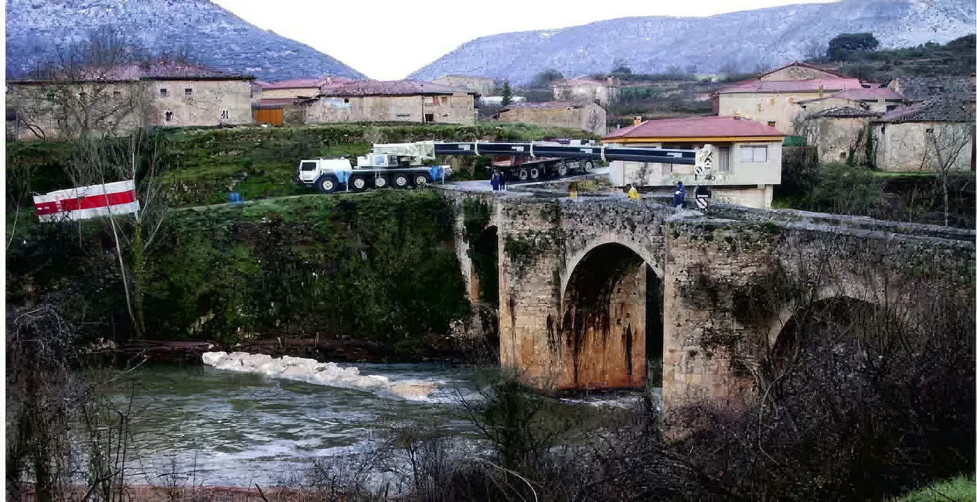 Grúa y camiones sobre el puente de Pesquera de Ebro durante el refuerzo de sus zapatas